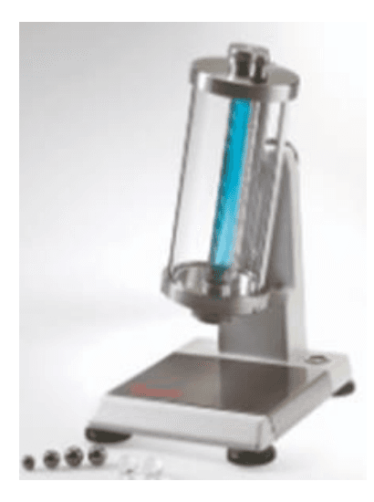 Photographie d'un viscosimètre à chute de bille de laboratoire : un tube vertical rempli d'un liquide bleu, maintenu par un bâti métallique posé sur un socle.