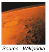 Photographie de la planète Mars vue depuis l'orbite : une surface orangée criblée de cratères, surmontée d'un fin liseré d'atmosphère sur fond noir. Source : Wikipédia.