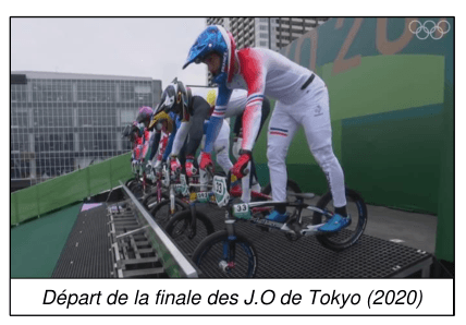 Photographie du départ de la finale de BMX des Jeux olympiques de Tokyo 2020 : huit pilotes casqués sont alignés sur la grille de départ, en équilibre sur leur vélo au sommet de la butte.